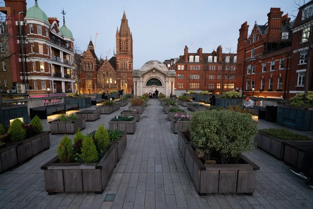 New Restaurants in Mayfair This Autumn and What Opens Next Brown Hart Gardens in Mayfair at dusk, a raised terrace with timber planters, benches and a domed stone pavilion