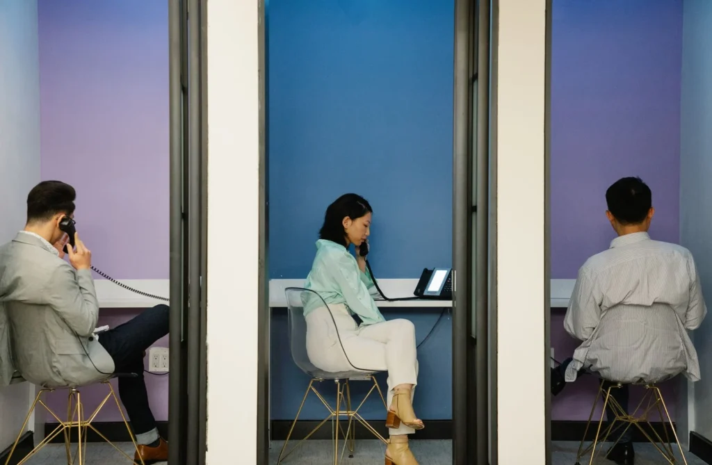 Making Every Square Foot Count: Smarter Office Design in Mayfair Three colleagues taking phone calls in separate private booths with glass doors in a modern office